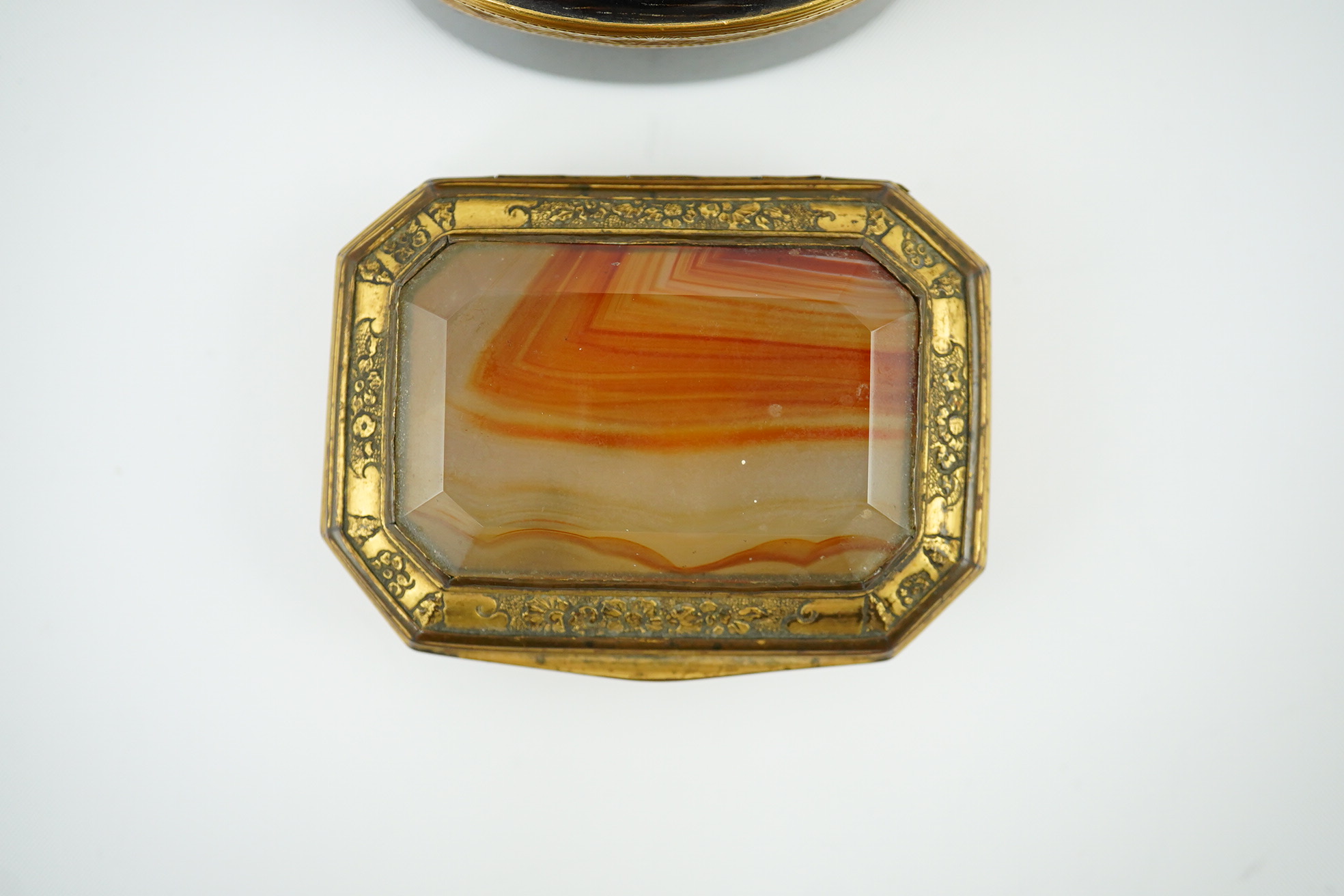 An early 19th century German gold mounted rutile agate? oval snuff box, 64mm and another gilt copper mounted agate snuff box.